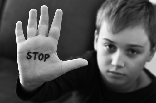Small,Abused,Boy,Holding,His,Hand,With,The,Word,'stop'